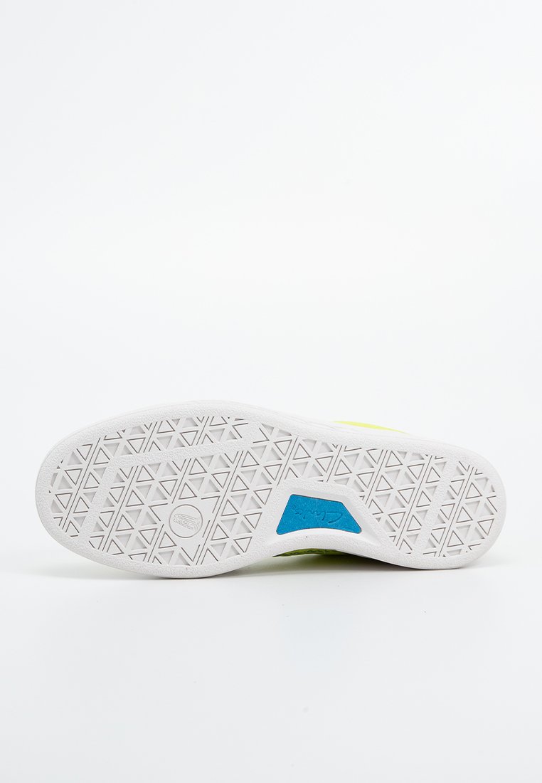 Suela de zapato de goma blanca con patrón de tachuelas en forma de triángulo. Presenta un acento azul y una parte superior vibrante en amarillo, mostrando un diseño atlético elegante.