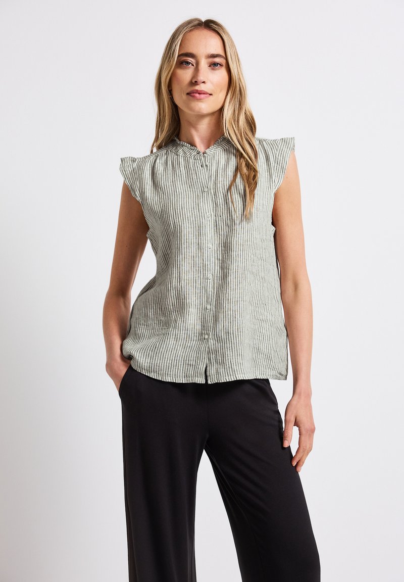 Blusa senza maniche a righe verde chiaro con chiusura a bottoni sul davanti, scollatura arricciata e tessuto morbido, abbinata a pantaloni neri a gamba larga.