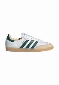 Sneakers in pelle bianca con accenti verdi, tre strisce sui lati, punta in khaki e suola in gomma. Presentano un design con lacci.