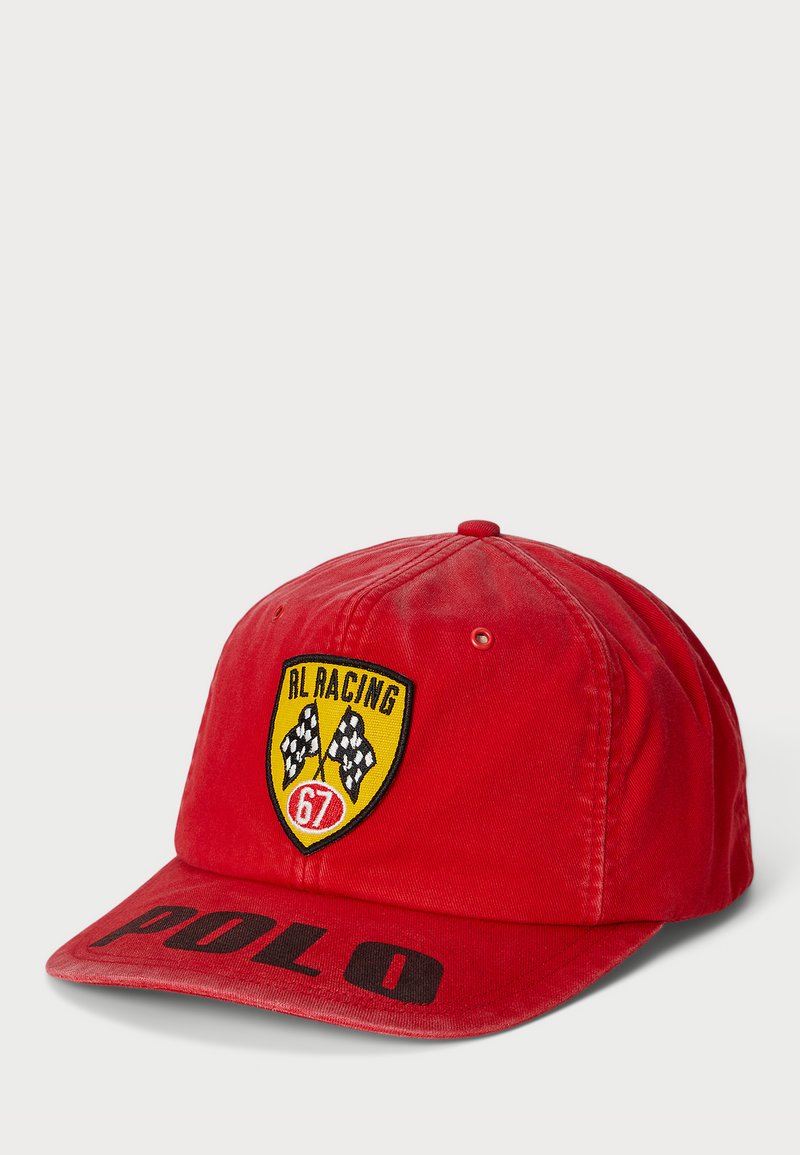Casquette de baseball en coton rouge avec un écusson brodé RL Racing jaune et noir, comportant des drapeaux à damier et '67'. Lettrage "POLO" noir sur le bord.