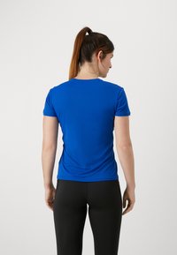 Blue athletic t-shirt with short sleeves, smooth texture, fitted design, and crew neckline, paired with black leggings.