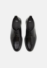Pantofi din piele neagră, cu șireturi, cu un finisaj neted și lucios, vârf rotund și talpă din cauciuc texturată; branding "BOSS" pe branț.