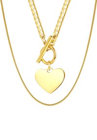 Gouden halsketting met meerdere kettingen, waaronder een gedraaide design. Aan een toggle-sluiting hangt een hartenhanger. Het oppervlak is glad en glanzend.