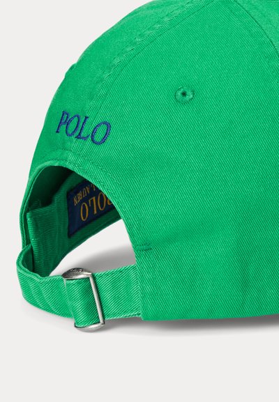 Grønn bomullslue med blå "POLO" broderi, justerbar rem med metallspenne, strukturert design og teksturert stoff.