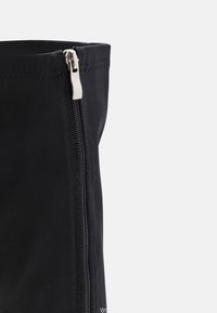 Botte en tissu noir avec fermeture éclair latérale, texture lisse et design simple et droit.