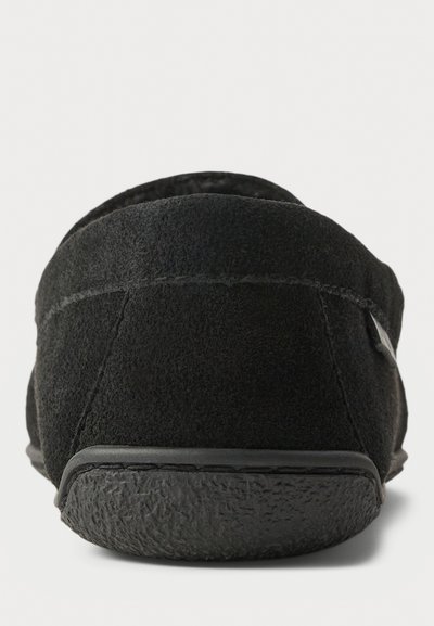 Čierne semišové šľapky s štruktúrovanou gumovou podrážkou a jemnými švy pozdĺž zadného švu a vrchného okraja.