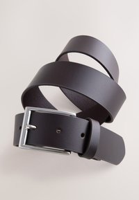 Cinturón de cuero marrón con textura suave, que presenta una hebilla de metal plateada y varios orificios para ajustar la talla.