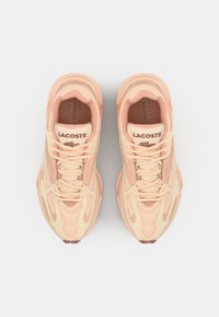 Lacoste sneakers with a mesh upper in light peach and cream, textured accents, and rounded toe. Features lace closure and logo detail.