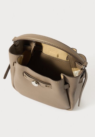 Kicsi taupe színű bőr kézitáska egyetlen pánttal, nyitott tetejű, ezüst gomb részletekkel és bézs velúr belső béléssel.