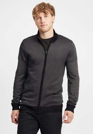 Suéter texturizado negro y gris con cremallera, que cuenta con puños y dobladillo acanalados, con un sutil patrón diagonal, diseñado para un ajuste ceñido.