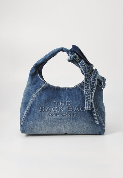 Sac tote en denim avec une poignée torsadée. Présente un texte en relief "THE SACK BAG" et "MARC JACOBS." Texture lisse avec un léger effet de décoloration.