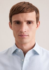 Hellblaues Hemd mit Knopfleiste und geometrischem Muster; verfügt über einen breiten Kragen und glatten Baumwollstoff.