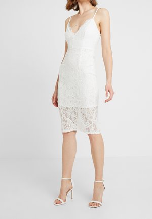Witte kanten jurk met een aansluitend ontwerp, dunne spaghetti-bandjes, een V-hals en een zoom tot halverwege de kuit.