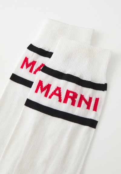 Vita strumpor med djärva svarta och röda ränder, där "MARNI" är vävt tydligt i rött på utsidan. Mjuk stickad material.