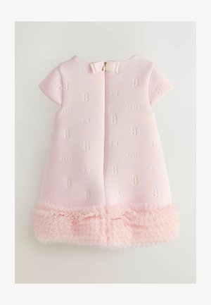 Vaaleanpunainen mekko, jossa on lyhyet hihat, kohokuvioitu kangas, jossa on kohopainetut 'B' ja rusetti-kuviot, sekä röyhelöinen tullehelma alareunassa. Takana vetoketjusuljenta.