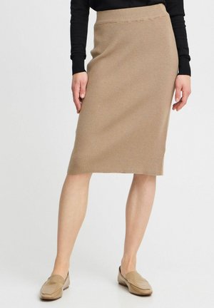 Strick-Midikleid in Hellbraun mit Ripptextur. Hoch sitzendes Design, knielanger Schnitt, kombiniert mit hellen Mokassins.