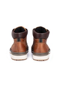 Bottes en cuir marron avec un col marron foncé, présentant une finition texturée, un soutien rembourré de la cheville et une semelle extérieure blanche et grise.