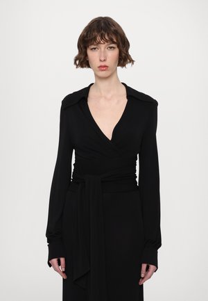 Black wrap dress with long sleeves, V-neck, and wide collar. Features a cinched waist with a tied sash. Smooth texture, form-fitting design.