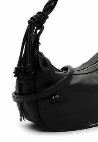 Musta nahkainen käsilaukku, jossa on löysä muoto, punotut yksityiskohdat hihnassa ja vetoketjullinen suljin turvallista pääsyä varten.