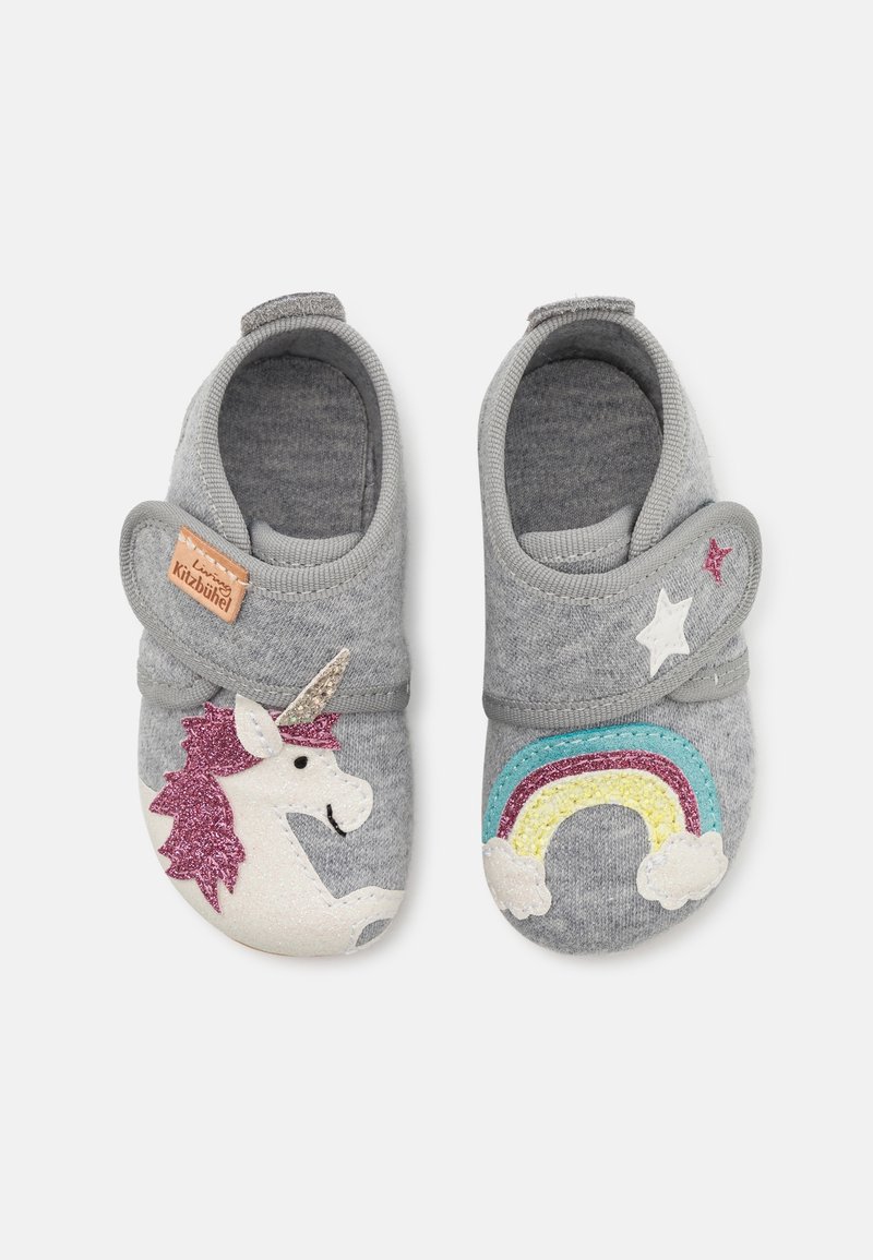 Grijze stoffen pantoffels hebben een eenhoorn met een glinsterende hoorn en een regenboog met wolkaccenten op elke schoen. Klittenbandsluiting.