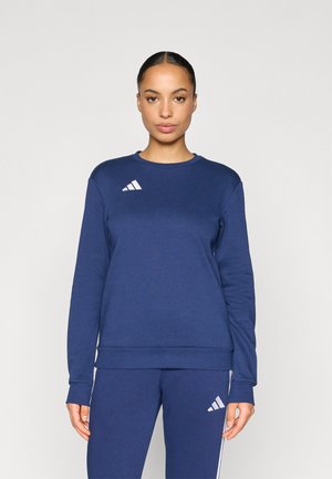 Mørkeblå sweatshirt med lange ærmer, rund halsudskæring og hvidt trestribet logo på venstre bryst. Tekstureret stof, afslappet pasform.