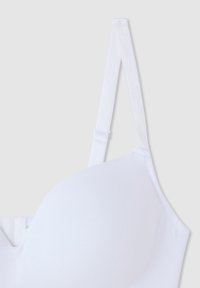 Reggiseno bianco con tessuto morbido, coppe sagomate, spalline regolabili e design senza cuciture. Presenta una chiusura con gancio e occhiello sul retro.
