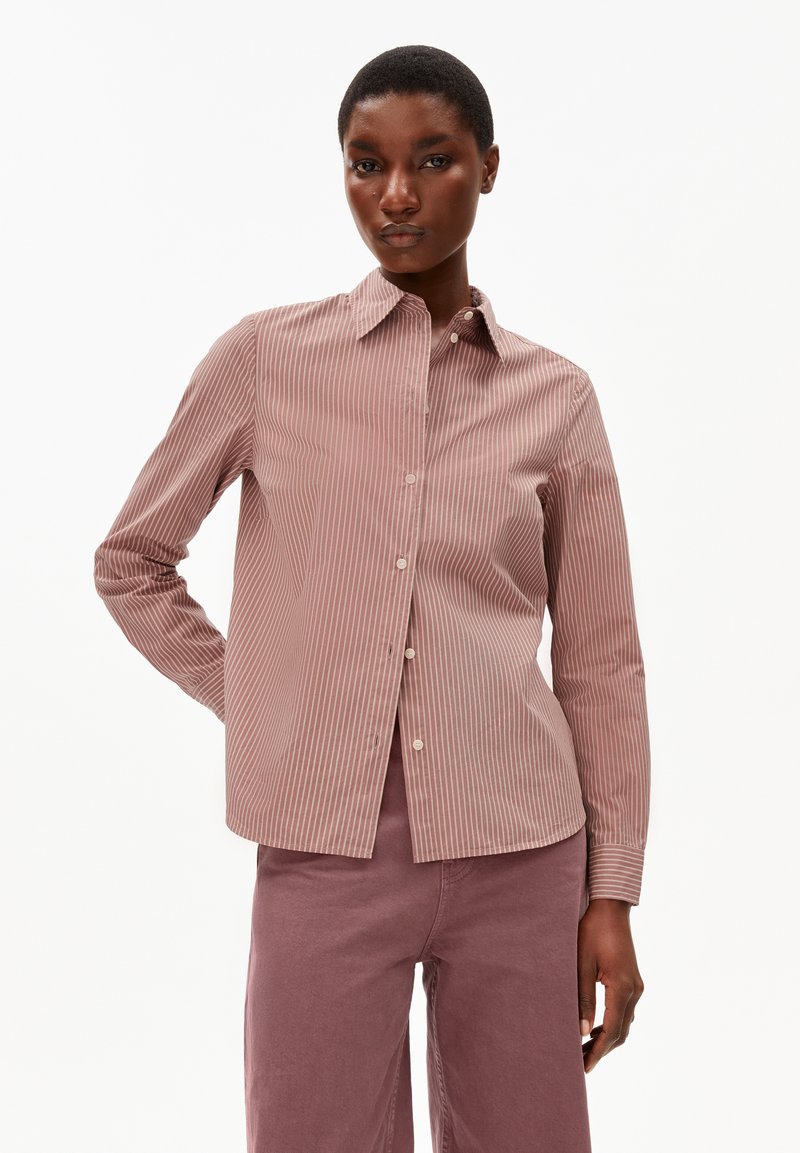 Camicia a righe in rosa polveroso, realizzata in tessuto leggero con colletto a polo e maniche lunghe, abbinata a pantaloni coordinati.