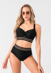Black bikini set featuring a knotted top with transparent striped accents and high-waisted bottom matching the top’s design.