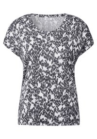Top de manga corta con estampado en blanco y negro, fabricado en una tela suave; cuenta con un escote redondeado y un corte holgado con hombros caídos.