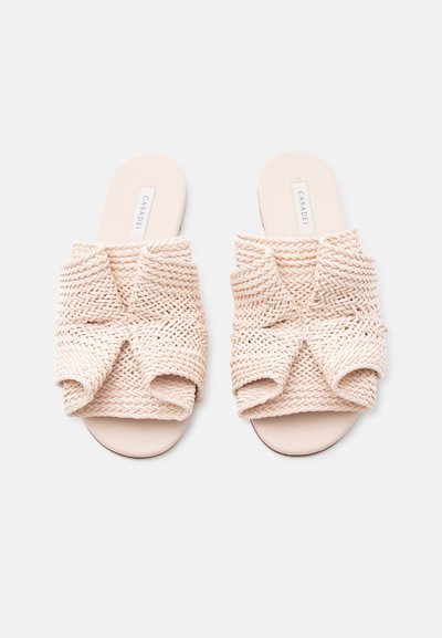 Μπεζ πλεκτές σαγιονάρες τύπου slide με φαρδιές, στριφογυριστές λουράκια και επίπεδες σόλες, με την ετικέτα "Casadei" στην εσωτερική σόλα.