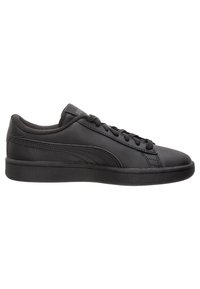 Chaussures de sport noires en cuir lisse, avec des lacets plats, un bout rond et une semelle en caoutchouc profilée basse. Marquage minimal sur la languette.