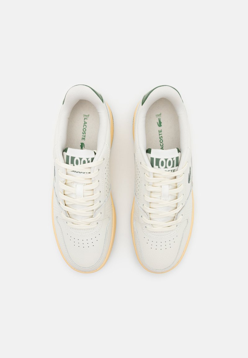 Baskets en cuir blanc avec des accents verts, design perforé, lacets plats et semelle en caoutchouc. Marque visible sur la languette et la semelle intérieure.