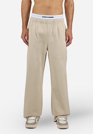 Beige wide-leg pants made from soft fabric, featuring an elastic waistband with "PEGADOR" logo. Sleek design with side pockets.