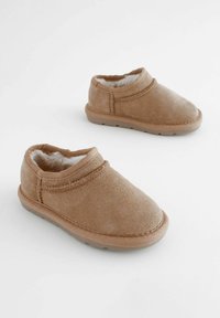 Tan suède pantoffels met een ronde neus en gestikte accenten. Gevoerd met nepbont, voorzien van een gestructureerde rubberen zool voor grip.