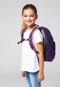 Zaino viola con accenti rosa, motivo floreale sulle cinghie, fibbia regolabile, schienale in rete, scomparti con zip funzionali e spallacci imbottiti.