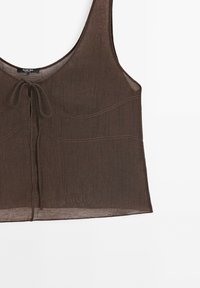 Top court marron sans manches avec un décolleté arrondi et un détail noué à l'avant, confectionné dans un tissu léger et légèrement transparent.