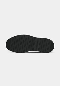 Sola de sapato de borracha preta com ranhuras horizontais para tração; apresenta uma leve curvatura na ponta e no calcanhar para um design ergonômico.