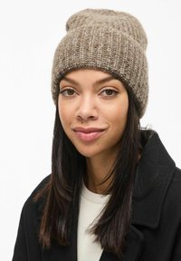 Brączowa dziana czapka beanie o prążkowanej teksturze, z lekko podwiniętym rondem i miękkim, ciepłym materiałem.