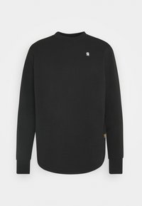 Sudadera negra de manga larga con cuello redondo, textura suave, puños detallados y un pequeño logo en el pecho. Diseño con dobladillo redondeado.