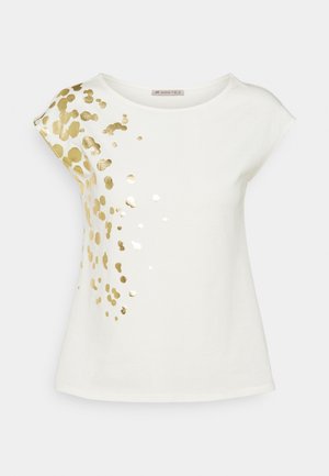Chemise blanche à manches courtes avec encolure arrondie et taches dorées dispersées concentrées sur l'épaule gauche et la partie supérieure de la poitrine.