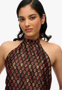 Top con collier in tessuto nero con intricati motivi floreali rossi e gialli. Texture liscia senza hardware o accenti visibili.