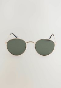 Sunglasses ovaaleilla tummanvihreillä linsseillä, kultaisella metallikehyksellä ja mustilla muovilangoilla. Varustettu teksturoidulla nenäsepalla lisäyksityiskohtia varten.