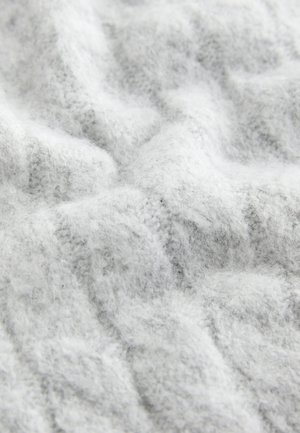 Helehall kudumiskangas, millel on pehme ja tekstuuriga pind, väikeste mustrite ning õrnade lainetega, luues hubase välimuse.