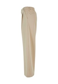 Pantalon beige en tissu lisse, avec une coupe ample, une taille élastique et des poches latérales. Design simple sans motifs visibles.