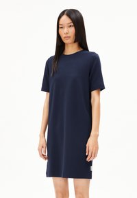 Robe bleu marine à manches courtes, en tissu doux, coupe décontractée, col rond, arrivant au-dessus du genou, avec une petite étiquette de logo sur l'ourlet.