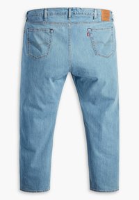 Jasnoniebieskie dżinsy z denimu o prostych nogawkach, pięcioma kieszeniami i skórzaną naszywką z logo na tylnej części pasa. Miękka faktura.