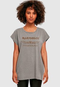 Grå oversized bomulds t-shirt med korte ærmer, prydet med "Iron Maiden Powerslave" grafisk tryk i brunt og rund halsudskæring.