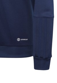 Marineblauwe sport sweatshirt van een gestructureerde stof, met ribboorden en een klein wit "AEROREADY" logo nabij de zoom.