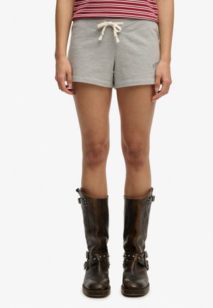 Persoon draagt grijze shorts met trekkoord, een rood-wit gestreept shirt en hoge donkerbruine leren laarzen met gespen.