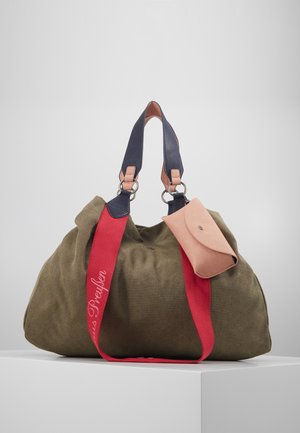 Olivegrüne Stofftasche in großer Form, mit marineblauen und rosa Lederträgern, rotem Akzentgurt und einem kleinen passenden Beutel, der befestigt ist.